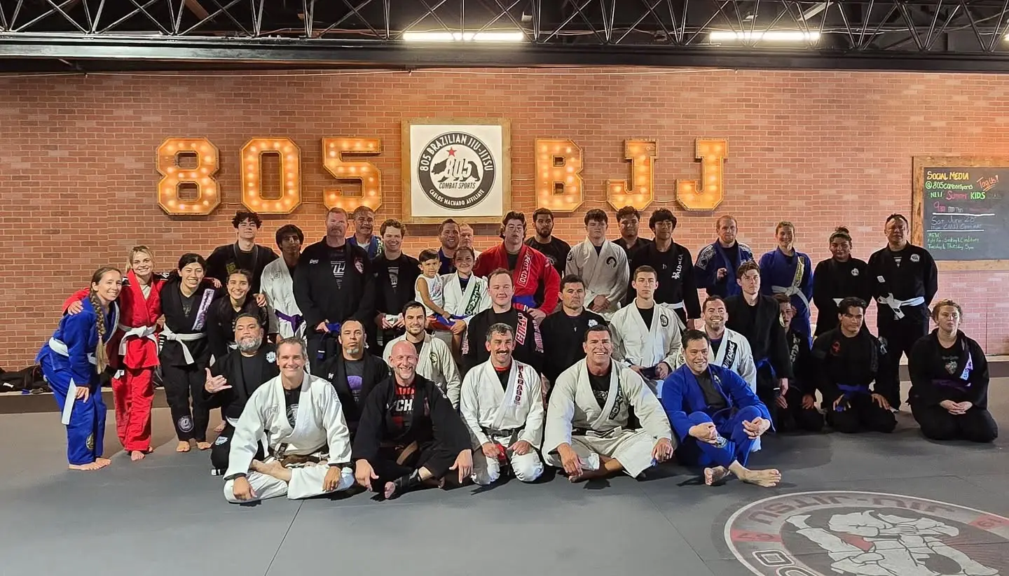 Adult members gathered on the mat under the 805 BJJ sign at 805 Combat Sports in Simi Valley