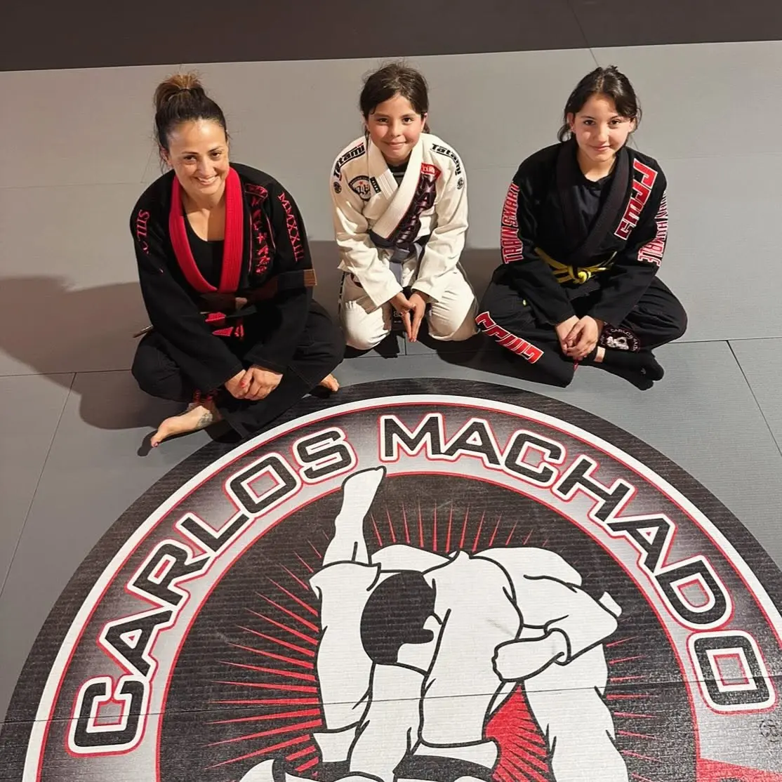 A coach and two young students smiling on the mat at 805 Combat Sports in Simi Valley
